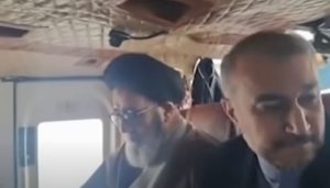 Image showing the wreckage of a helicopter crash in a mountainous region, with rescue workers and officials inspecting the site. The crash, which occurred on May 22, 2024, tragically claimed the life of Iran's President Ebrahim Raisi