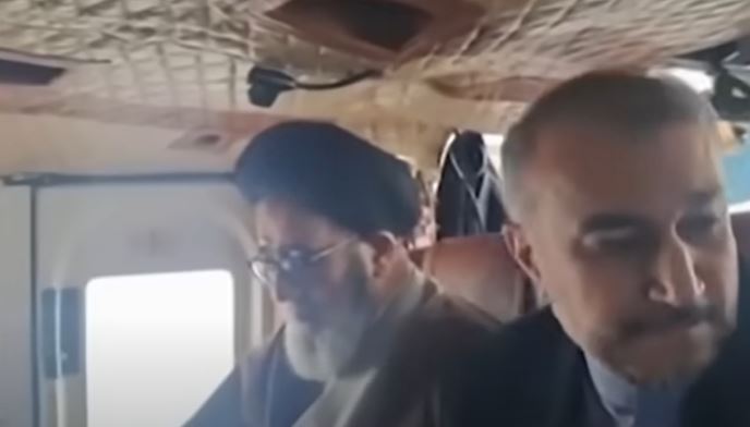 Image showing the wreckage of a helicopter crash in a mountainous region, with rescue workers and officials inspecting the site. The crash, which occurred on May 22, 2024, tragically claimed the life of Iran's President Ebrahim Raisi